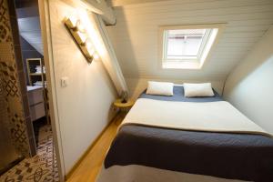 a small bedroom with two beds and a window at Appartement Les Tournesols avec Climatisation in Kaysersberg