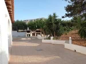 un patio con palmeras y una montaña en el fondo en Flower Apartments, en Gouves