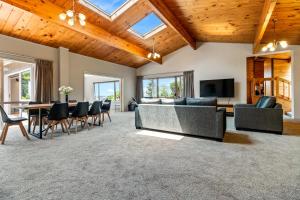 a living room with a couch and a table and chairs at Country Retreat - Athenree Holiday Home in Waihi Beach