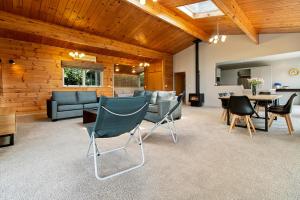 a living room with chairs and a dining room at Country Retreat - Athenree Holiday Home in Waihi Beach