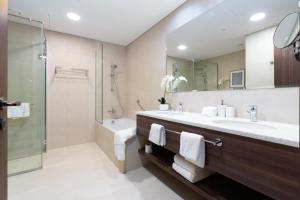 a bathroom with a sink and a shower at Ultimate Stay Avani next to Palm Jumeirah in Dubai