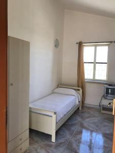 Un dormitorio pequeño con una cama y una ventana. en Vento Di Ponente House, en Pachino