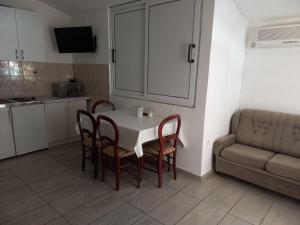 cocina con mesa, sillas y sofá en Apartments Kraljevic en Podaca