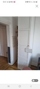a room with a white door with a shelf at Appartement cosy en plein centre in Guidel