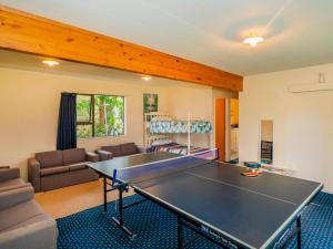 a living room with a ping pong table at Oyster Bach - Cooks Beach Bach in Cooks Beach
