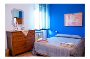 a blue bedroom with a bed and a dresser at Al 54 in San Giorgio Di Mantova