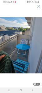 een blauwe tafel en stoelen op een balkon bij Appartement cosy en plein centre in Guidel