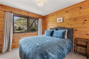 a bedroom with a bed and a window at River Road Spa Lodge - Broadlands Forest in Taupo