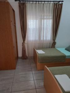 Habitación con 2 camas y ventana con cortinas. en Apartments Kraljevic en Podaca