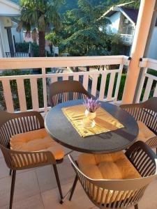 a table and chairs on a balcony with a table and flowers at Apartments Kraljevic in Podaca