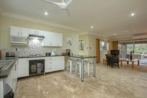 a kitchen with white cabinets and a black counter top at Kruger's Retreat House & Kruger's Rest Studio in Marloth Park +29 photos