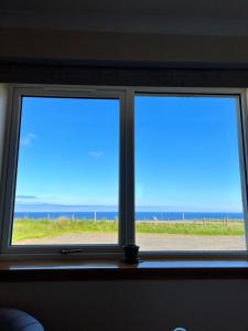 two windows in a room with a view of the ocean at Alba Sunrise in Keiss