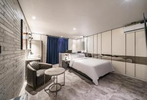 a bedroom with a bed and a couch and a chair at Brown-Dot Hotel Geomdan in Incheon