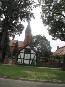 un edificio con una torre de reloj en un patio en Haus am Luch, en Markische Heide