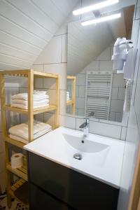 a bathroom with a sink and a mirror at Appartement Les Tournesols avec Climatisation in Kaysersberg