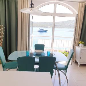 d'une salle à manger avec une table, des chaises et une fenêtre. dans l'établissement Aparthotel Marina, à Primošten