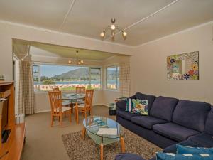 a living room with a couch and a table at Breakaway - Tairua Bach in Tairua
