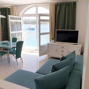 a living room with a couch and a tv and a table at Aparthotel Marina in Primošten