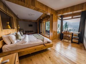 a bedroom with a bed and a table with a desk at Famree Resort Hunza in Hunza Valley