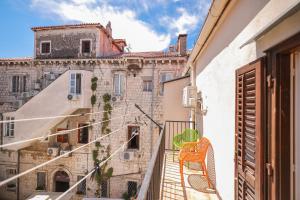 a chair sitting on a balcony in front of a building at Two bedroom apartment in city center Igor in Zadar