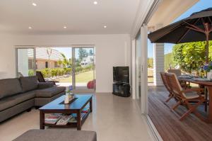 a living room with a couch and a table at Paradise at Pauanui - Pauanui Holiday Home in Pauanui