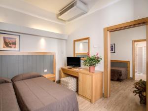 a bedroom with a bed and a desk with a computer at Hotel Delle Nazioni in Florence