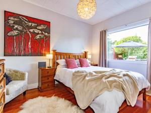 a bedroom with a bed and a couch and a window at Stag & 3 Pigs - Ohakune Holiday Home in Ohakune