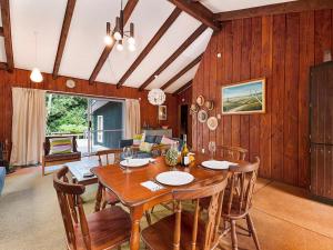 una sala da pranzo con tavolo e sedie in legno di Te Kuru Cabin - Pukawa Bay Holiday Home a Kuratau