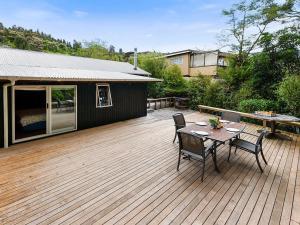 a wooden deck with a table and chairs on it at Te Kuru Cabin - Pukawa Bay Holiday Home in Kuratau