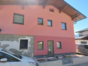 a house that is painted pink at Sonnfeld Appartement in Sankt Veit im Pongau
