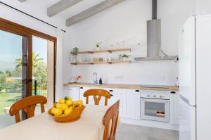 kuchnia ze stołem, na którym stoi miska z owocami w obiekcie YourHouse Can Covetes, villa with private pool and garden, perfect for families w mieście Muro