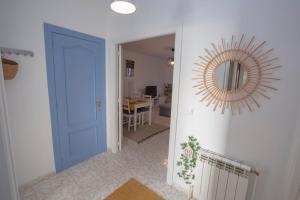 un pasillo con una puerta azul y un espejo en Ebro Alojamiento VUT 47-314, en Arroyo de la Encomienda