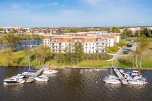a group of boats are docked in a harbor at Marina Glamour Apartment plus parking w hali in Iława