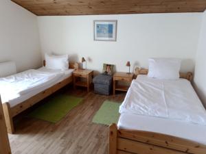 two beds in a room with wooden floors at Hof Kranichweide, Ferienwohnung "Skinfaxi" in Saal