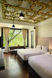 Un dormitorio con dos camas y una sala de estar. en Hotel Heritage Inn at Assi Ghat, en Varanasi 37 fotos más