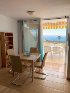 a dining room with a table and chairs and a view of the ocean at Ocean View, Große Sonnenterrasse, Meerblick, Tamara Komplex, Teneriffa Süd, Los Gigantes, 500m Strand, Pool, 300m zum Ort, ruhig in Acantilado de los Gigantes