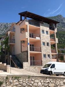 a white van parked in front of a building at Apartments PEHAR in Podaca