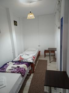 two twin beds in a room with a table at Casa Bekirebeki in Vama Veche