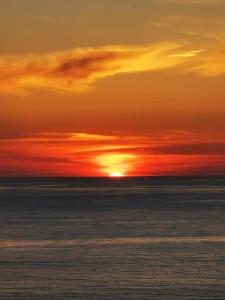 una puesta de sol sobre el océano con el sol en el cielo en Villetta sul mare, en Acquedolci