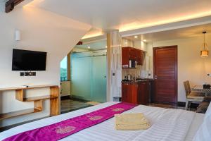 sypialnia z łóżkiem i telewizorem na ścianie w obiekcie Kyara Villa Apartments w mieście Canggu