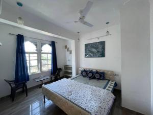 a bedroom with a bed with blue pillows in it at Boraj Haveli Guest House in Udaipur
