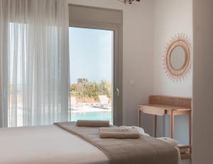 a bedroom with a bed and a large glass window at Alykes Beachside Stylish Villas with Private Pool South Rhodes in Lakhania