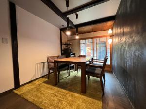 - une salle à manger avec une table et des chaises en bois dans l'établissement kuon hotel kyoto shichijo, à Kyoto