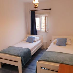 two beds in a room with a window at Aparthotel Marina in Primošten