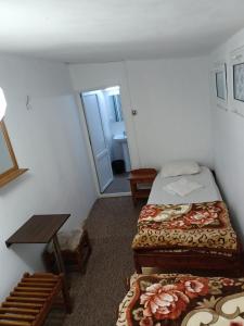 mały pokój z 2 łóżkami i stołem w obiekcie Casa Bekirebeki w mieście Vama Veche