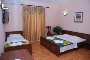 two beds in a living room with a table at Firenze Apartments in Ulcinj