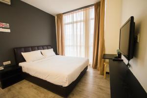 a bedroom with a bed and a large window at Sandy Hotel Malacca in Malacca