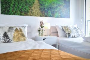 a bedroom with two beds and a painting on the wall at Habitat Esslingen in Esslingen