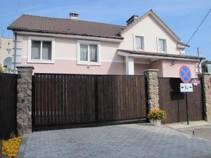 una casa con una puerta de madera y una valla en Guesthouse on Zygina Street, en Polatsk