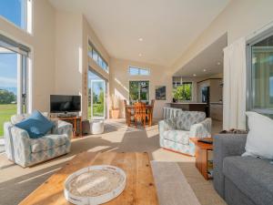 a living room with a couch and a table at Golfers and Beach Lovers Dream - Matarangi House in Matarangi